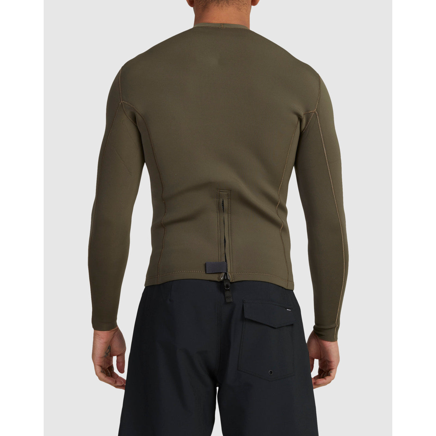 Person wearing a green long-sleeve shirt and black pants on a white background