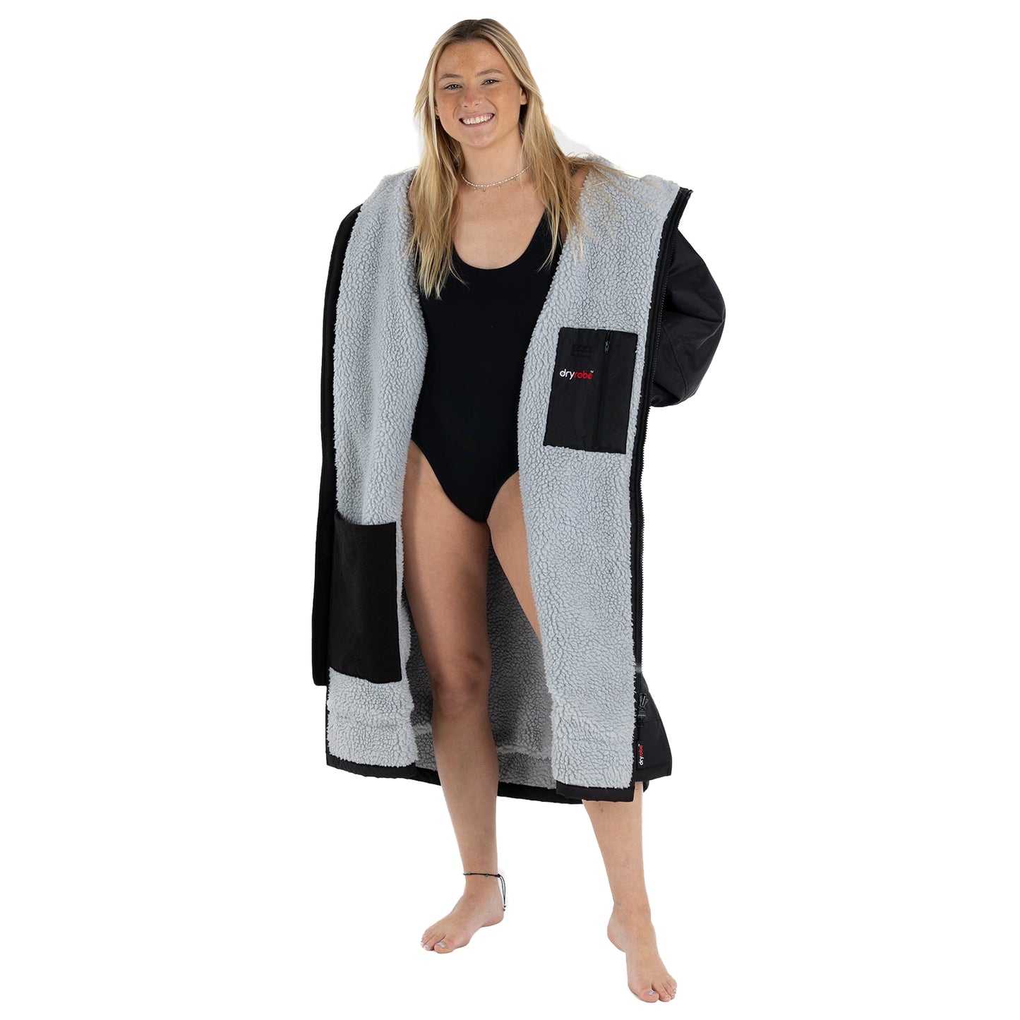 Woman wearing a black and gray robe over a swimsuit on a white background